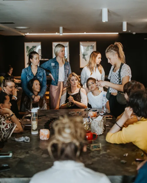 A group of people sitting or standing around a table